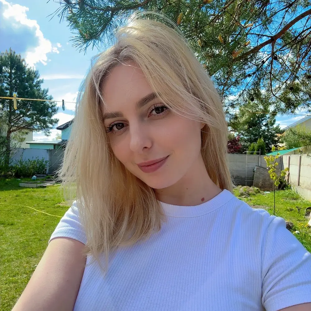 Home a bright, outdoor selfie of a young woman with shoulder length blonde hair and a gentle smile